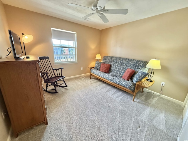 sitting room with baseboards, light carpet, and ceiling fan