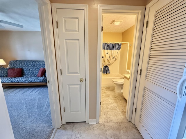 hall featuring light carpet and a textured ceiling