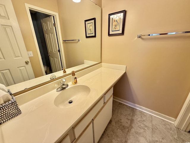 bathroom with baseboards, toilet, vanity, and tile patterned flooring