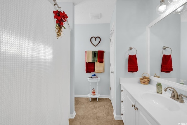 bathroom featuring baseboards, vanity, and tile patterned flooring