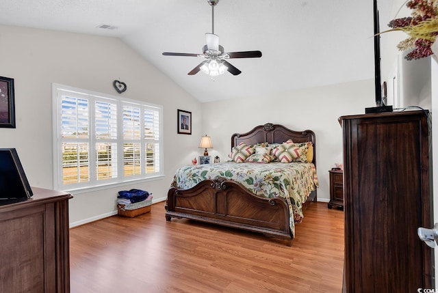 bedroom featuring a ceiling fan, baseboards, visible vents, vaulted ceiling, and light wood-type flooring