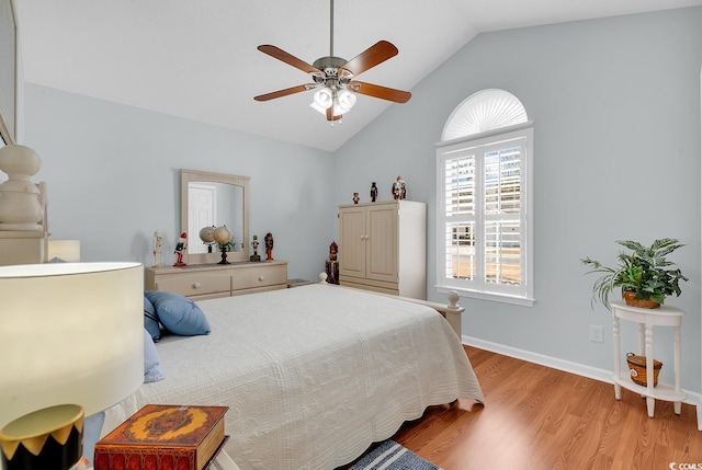 bedroom with lofted ceiling, light wood-style flooring, a ceiling fan, and baseboards