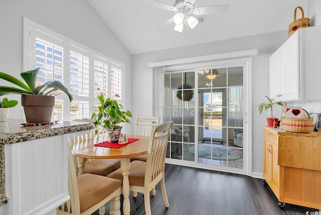 dining space with lofted ceiling, dark wood-style floors, a wealth of natural light, and ceiling fan