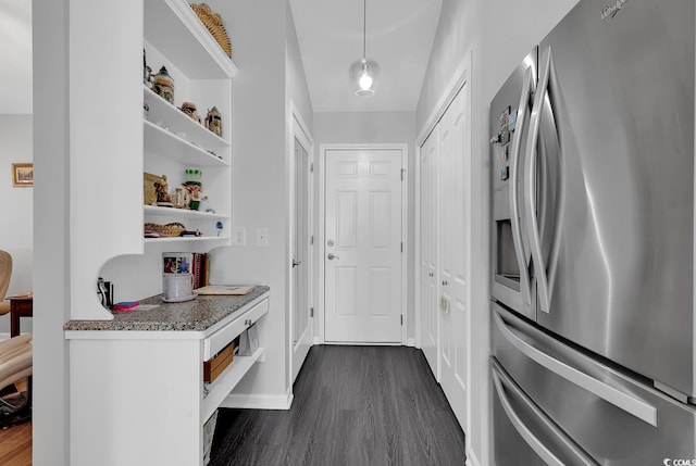 kitchen featuring dark wood-style flooring, stainless steel fridge, baseboards, and open shelves