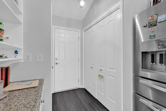 kitchen with open shelves, light stone countertops, stainless steel refrigerator with ice dispenser, and dark wood-style flooring