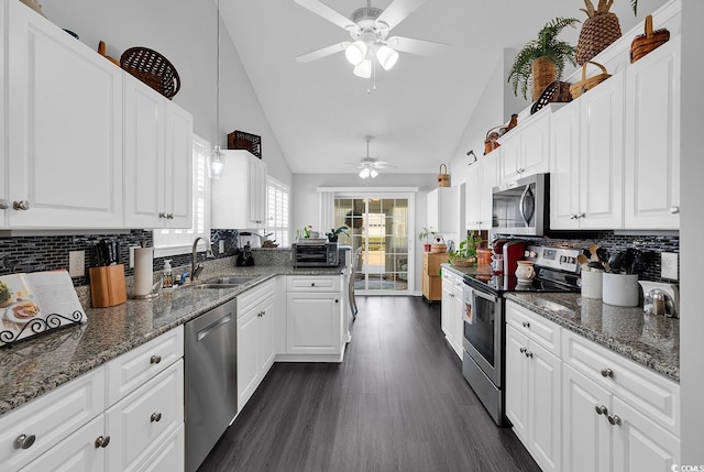 kitchen with a ceiling fan, a sink, appliances with stainless steel finishes, white cabinets, and dark wood-style flooring