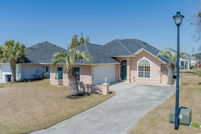 single story home with a shingled roof, an attached garage, driveway, and stucco siding