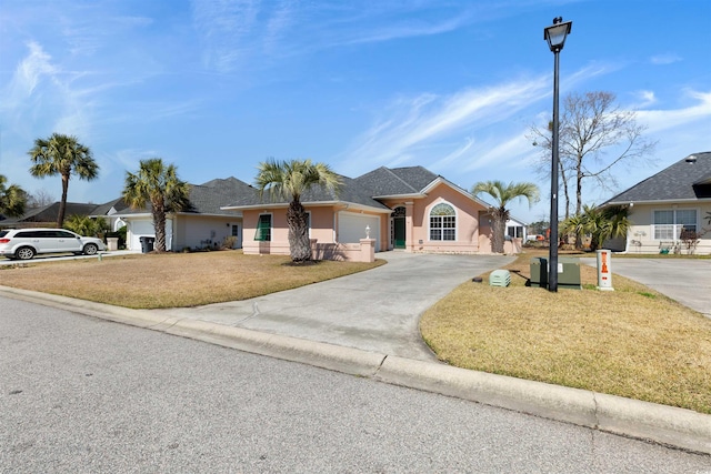 single story home with a front yard, an attached garage, driveway, and stucco siding