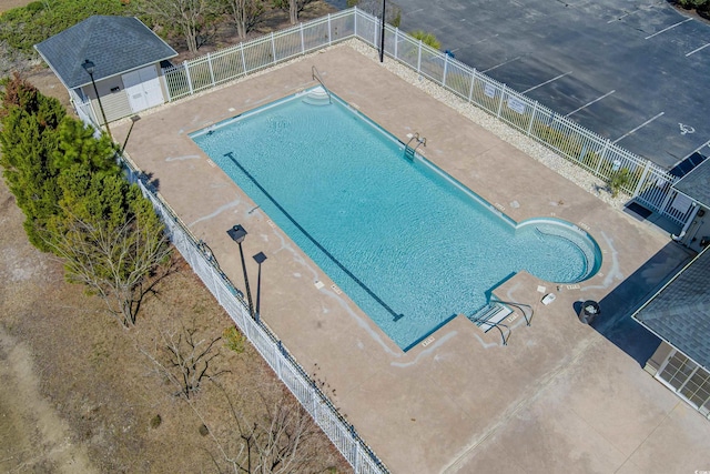 pool with a patio and fence