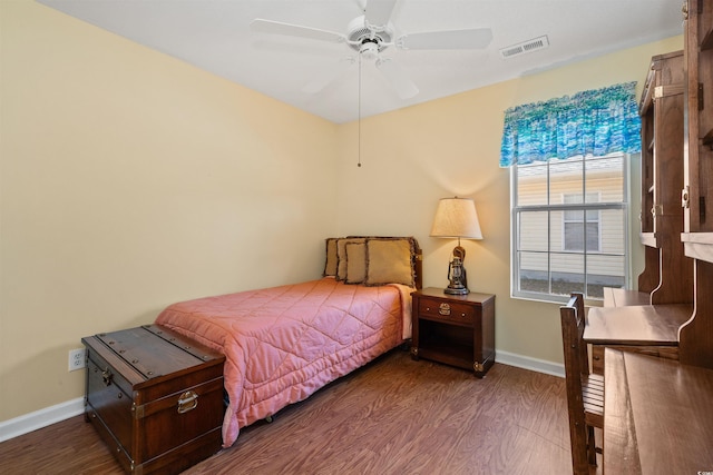 bedroom featuring visible vents, a ceiling fan, baseboards, and wood finished floors