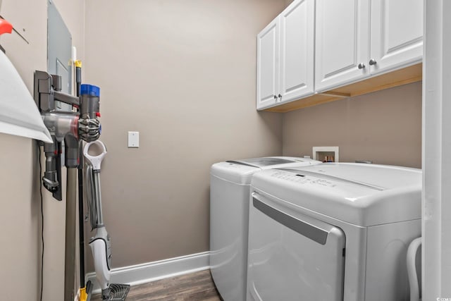 laundry area with dark wood-type flooring, cabinet space, baseboards, and washing machine and clothes dryer