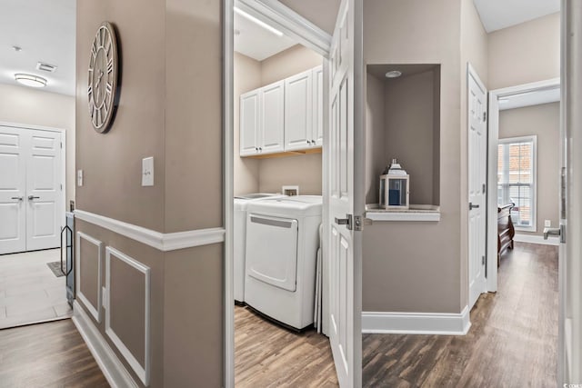 laundry room with cabinet space, hookup for a washing machine, baseboards, and wood finished floors