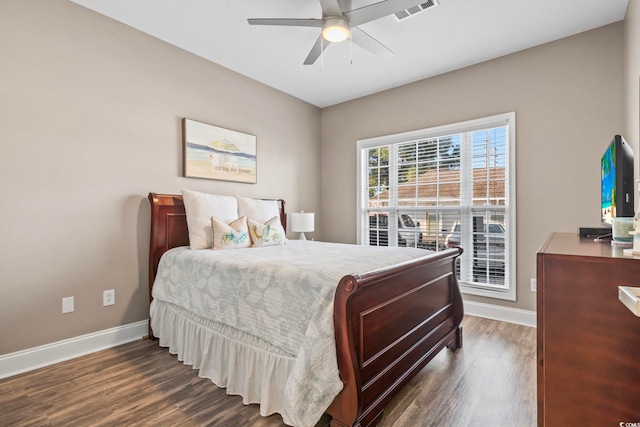 bedroom with dark wood-style floors, visible vents, ceiling fan, and baseboards