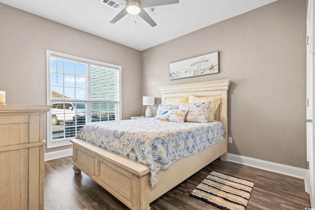 bedroom with dark wood finished floors, visible vents, ceiling fan, and baseboards