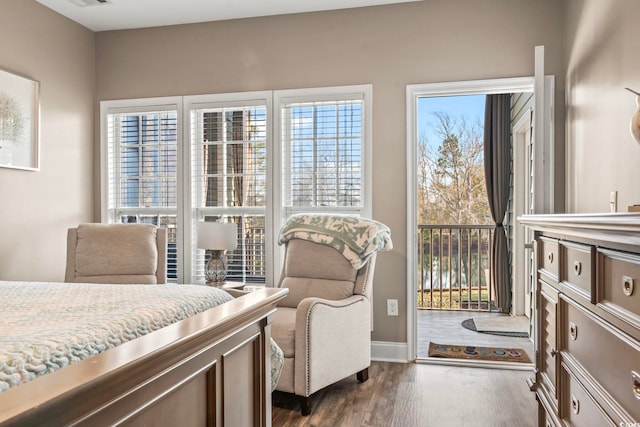 bedroom with multiple windows, access to exterior, and dark wood-style flooring