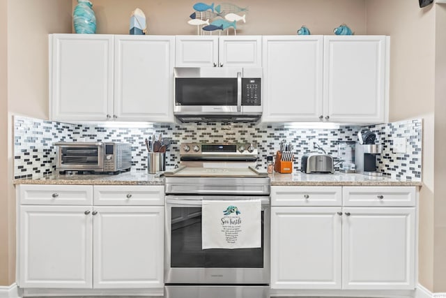 kitchen with a toaster, backsplash, appliances with stainless steel finishes, and white cabinetry