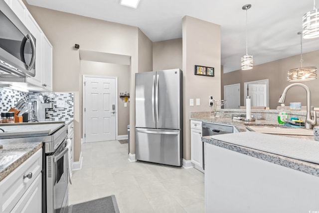 kitchen with a sink, decorative backsplash, hanging light fixtures, white cabinets, and appliances with stainless steel finishes