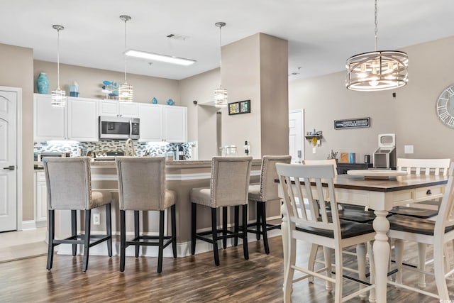 dining room featuring a notable chandelier, visible vents, and wood finished floors