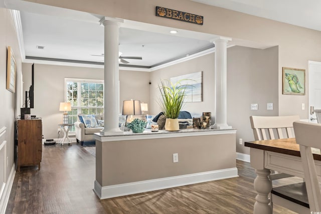 interior space featuring decorative columns, baseboards, dark wood finished floors, and crown molding