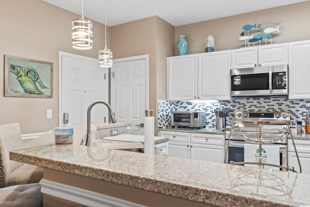 kitchen featuring light stone countertops, a toaster, decorative backsplash, stainless steel appliances, and a sink