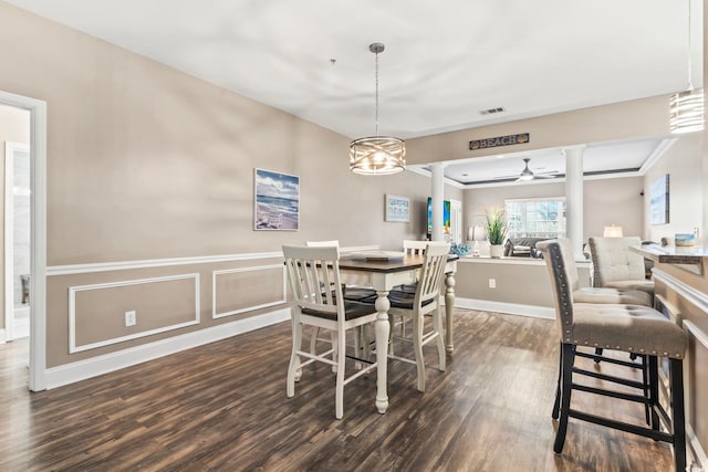 dining area featuring visible vents, dark wood finished floors, wainscoting, ceiling fan, and ornate columns