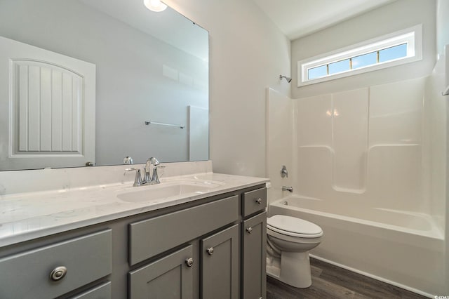 bathroom featuring vanity, toilet, wood finished floors, and tub / shower combination