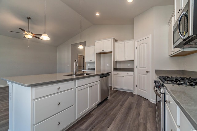 kitchen with dark wood-type flooring, ceiling fan, appliances with stainless steel finishes, white cabinets, and a sink