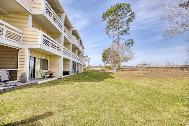 view of yard with a balcony and a patio area