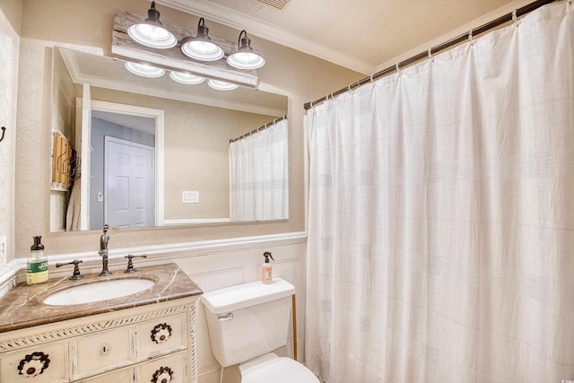 full bathroom featuring wainscoting, toilet, vanity, and ornamental molding