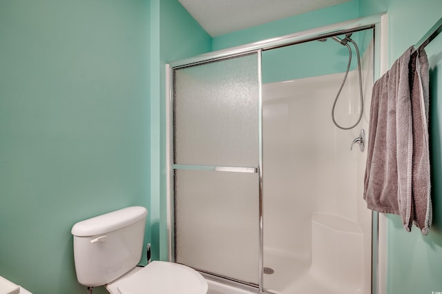 bathroom featuring a stall shower and toilet