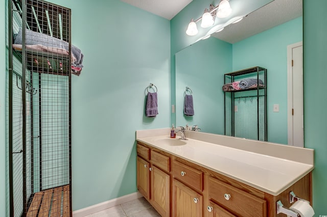 full bathroom with vanity, tile patterned floors, and baseboards