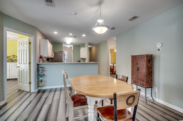 dining room with light wood-style flooring, recessed lighting, baseboards, and visible vents