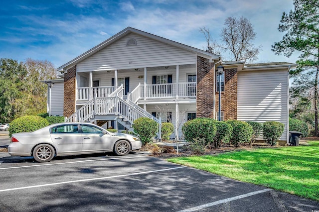 view of property featuring stairway and uncovered parking