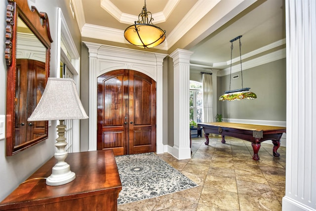 entrance foyer featuring crown molding, pool table, a raised ceiling, and decorative columns