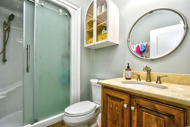 bathroom with a stall shower, toilet, and vanity