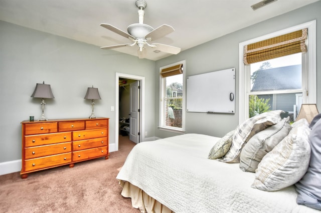 carpeted bedroom with a ceiling fan, baseboards, visible vents, a spacious closet, and a closet