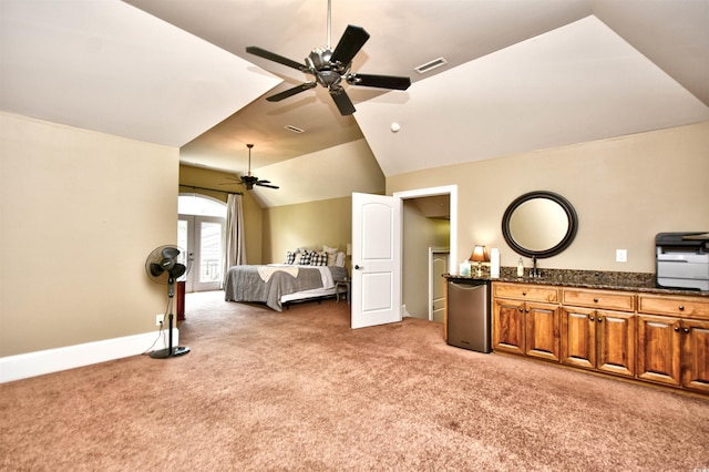 bedroom with visible vents, light colored carpet, fridge, and vaulted ceiling