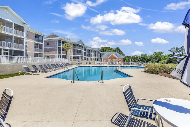 community pool featuring fence and a patio area