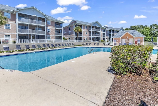 pool with a patio and fence