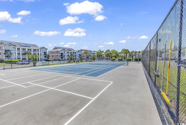 view of sport court featuring a residential view and fence