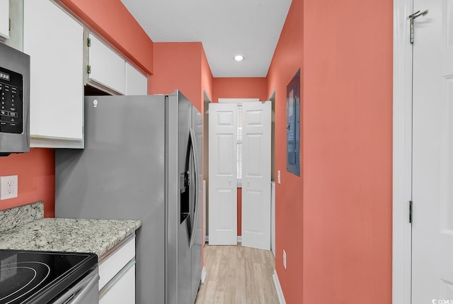 kitchen featuring light stone countertops, baseboards, stainless steel appliances, white cabinetry, and light wood-type flooring