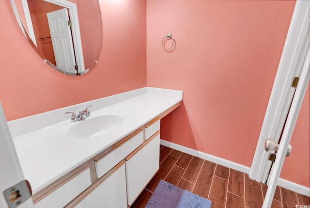 bathroom featuring wood finish floors, baseboards, and vanity