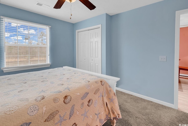 carpeted bedroom featuring a ceiling fan, baseboards, visible vents, and a closet