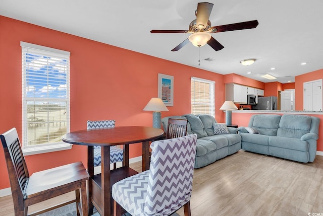 living area featuring visible vents, plenty of natural light, ceiling fan, and light wood finished floors