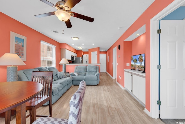 living room featuring a ceiling fan, visible vents, baseboards, light wood-style flooring, and recessed lighting