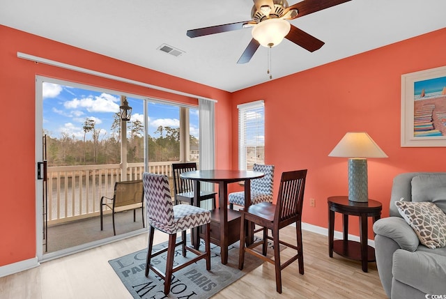 dining space featuring visible vents, baseboards, light wood-type flooring, and a ceiling fan