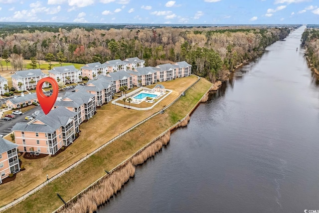 drone / aerial view with a forest view and a water view