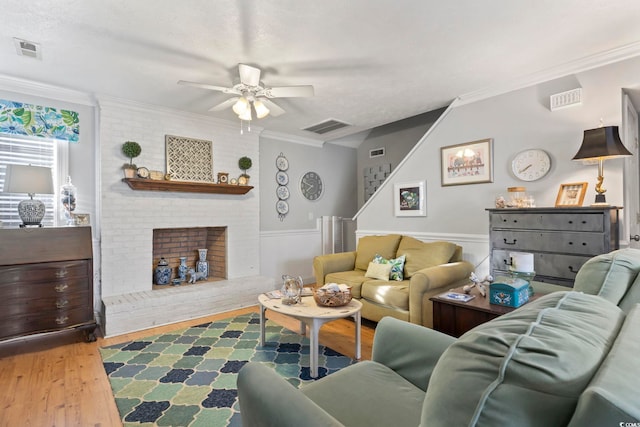 living area featuring visible vents, wood finished floors, ceiling fan, and ornamental molding