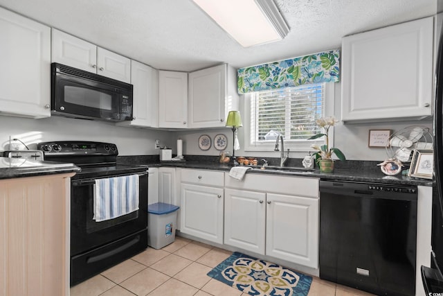 kitchen featuring light tile patterned floors, dark countertops, black appliances, and white cabinets