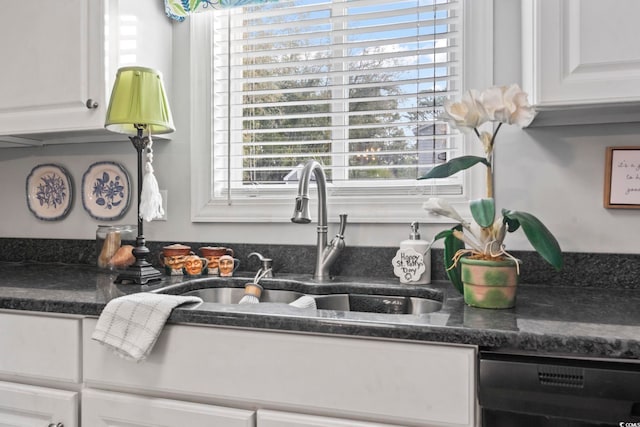 kitchen with white cabinets, black dishwasher, and a sink